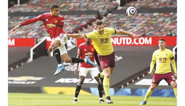 Manchester Unitedu2019s Mason Greenwood (left) jumps to win a header during the Premier League match against Burnley at Old Trafford in Manchester, England, yesterday. (AFP)