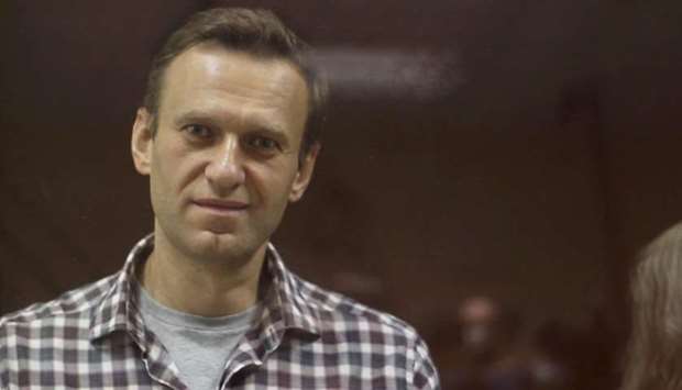 FILE PHOTO: Kremlin critic Alexei Navalny, who is accused of slandering a Russian World War Two veteran, stands inside a defendant dock during a court hearing in Moscow, Russia, Russia February 20, 2021, in this still image taken from video.(REUTERS