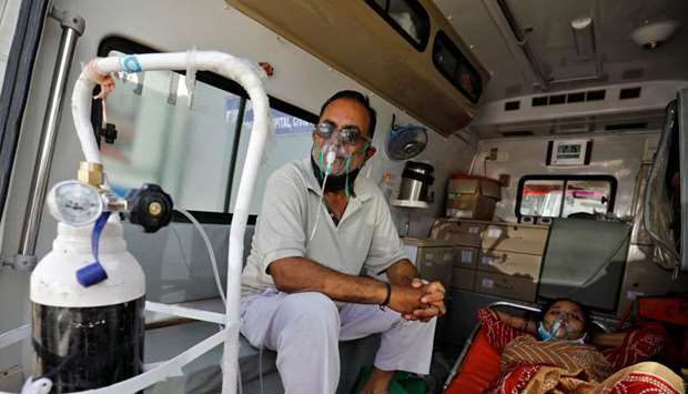 Patients with a breathing problem wait inside an ambulance to enter a Covid-19 hospital for treatmen