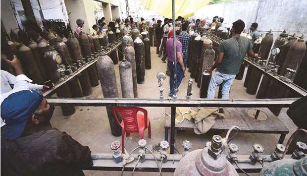 People refill medical oxygen cylinders for Covid-19 patients at an oxygen refilling station in Allahabad yesterday.