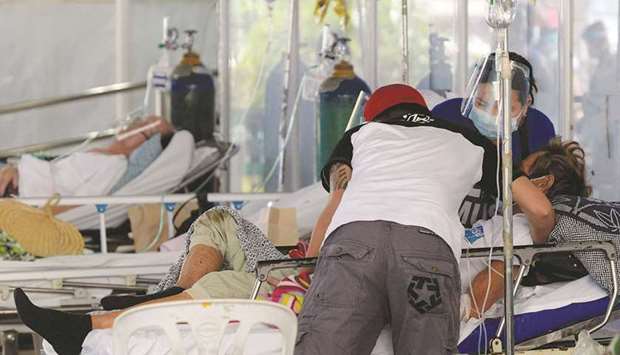 Family member assist a suspected Covid-19 patient lying on a hospital bed outside the emergency room of Amang Rodriguez Memorial Medical Center, in Marikina City, Metro Manila, Philippines.