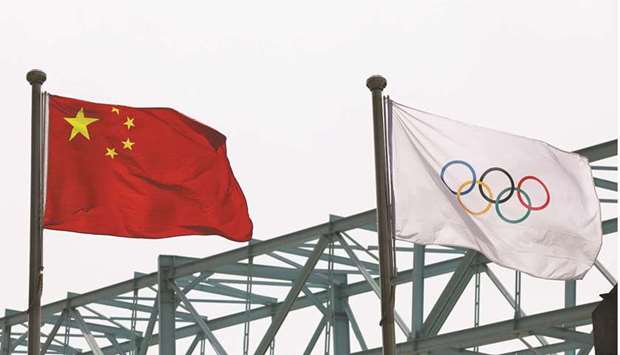 A Chinese national flag flutters next to an Olympic flag at the Beijing Organising Committee for the 2022 Olympic and Paralympic Winter Games, in Beijing, on March 30, 2021. (Reuters)