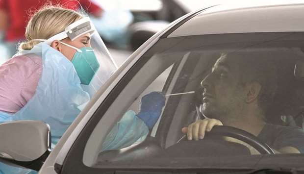 A medical professional administers a coronavirus disease (Covid-19) test on a member of the public at a drive-through clinic as authorities try to suppress a growing cluster of cases in Brisbane.