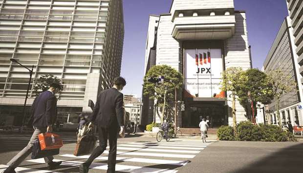 Pedestrians cross a road in front of the Tokyo Stock Exchange. The Nikkei 225 closed up 1.6% to 29,854.00 points yesterday.