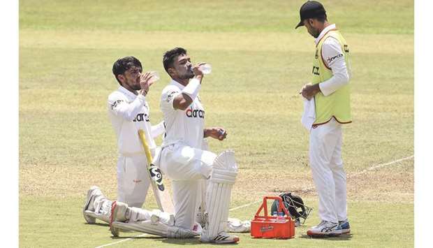 Bangladeshu2019s Najmul Hossain Shanto (C) and teammate Mominul Haque (L) drink water during the second day of the first Test cricket match against Sri Lanka at the Pallekele International Cricket Stadium in Kandy yesterday.