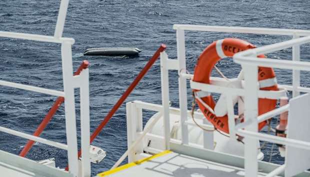 A rubber boat is seen after having capsized with more than 100 migrants on board, during a search and rescue (SAR) operation in the Mediterranean Sea, off the Libyan Coast