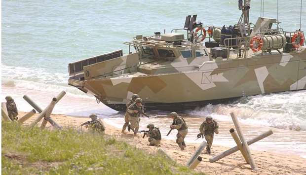 A handout picture released by the Russian Defence Ministry yesterday shows Russian forces landing ashore and taking part in a military drill along the Opuk training ground not far from the town of Kerch on the Kerch Peninsula in the east of the Crimea. (AFP)