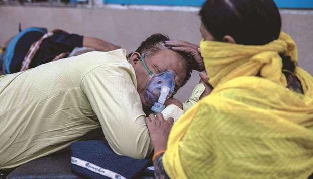 A woman takes care of her husband who is suffering from the coronavirus disease (Covid-19) as he waits to get admitted outside the casualty ward at Guru Teg Bahadur hospital, amidst the spread of the disease in New Delhi, yesterday.