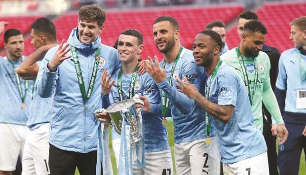 From left: Manchester Cityu2019s John Stones, Phil Foden, Kyle Walker and Raheem Sterling celebrate with the trophy after winning the League Cup yesterday. (AFP)