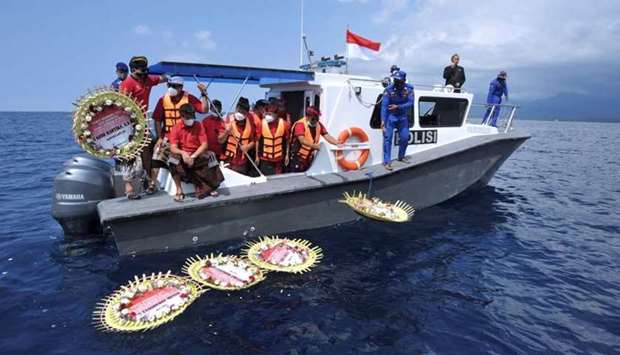 People throw flowers and petals with names of the sunken KRI Nanggala-402 submarine crew members from the boat during a prayer at the sea near Labuhan Lalang, Bali, Indonesia April 26.  Antara Foto/Fikri Yusuf/via Reuters