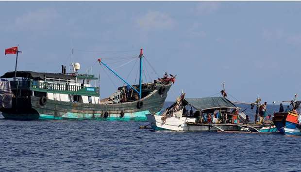 (file photo) A Chinese fishing vessel is anchored next to Filipino fishing boats at the disputed Scarborough Shoal