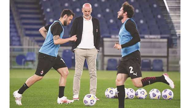 AC Milan coach Stefano Pioli (centre) watches his players warm up before the Serie A match against Lazio in Rome, Italy, on Monday. Lazio had won the match 3-0. (Reuters)