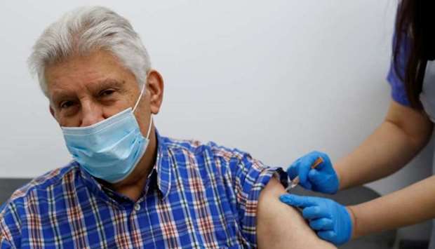 An elderly person receives a dose of the Oxford/AstraZeneca vaccine at Cullimore Chemist, in Edgware, London, Britain January 14, 2021