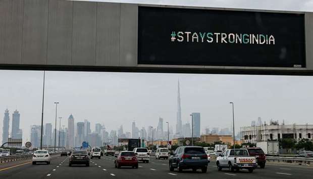 Vehicles drive beneath an electronic billboard bearing the message u2018#StayStrongIndiau2019 (as a sign of support between the United Arab Emirates and India against a surge of Covid-19 coronavirus cases) along a highway in Dubai