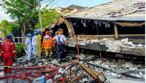 Rescue workers looking at the wreckage of a building after it collapsed in Bangkok. AFP/Poh Teck Tung Foundation
