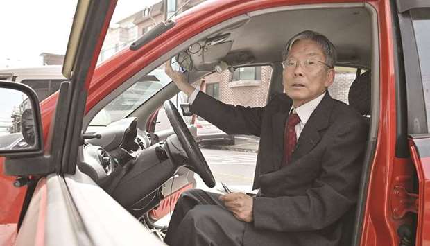 Picture taken on March 29 shows retired South Korean professor Han Min-hong sitting in his 21-year-old self-driving car in front of his office in Yongin, south of Seoul.