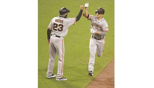 Mike Yastrzemski (right) of the San Francisco Giants is congratulated by Ron Wotus after hitting a solo home run during the seventh inning of their MLB game against the San Diego Padres at Petco Park in San Diego. (Getty Images/AFP)