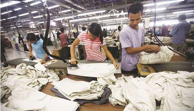 Workers iron and arrange clothing at a garment factory at Hlaing Taryar  industrial zone in Yangon (file).