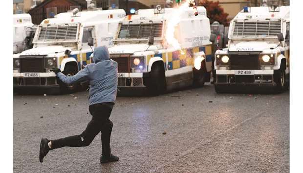 A rioter throws a Molotov cocktail at the police on the Springfield Road as protests continue yesterday in Belfast.