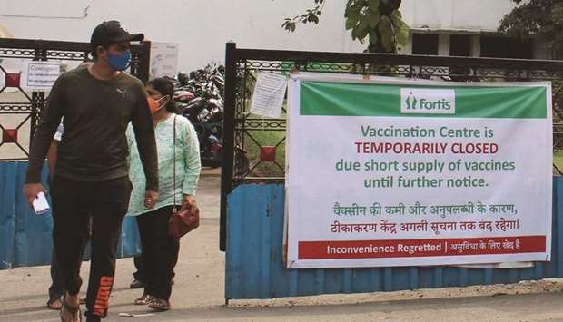 People walk past a banner announcing the temporary closure of a vaccination centre due to shortage of vaccine supplies, at Fortis hospital in Mumbai, yesterday, amidst the rising Covid-19 coronavirus cases.