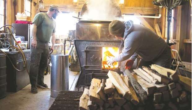 Men load wood into a burner while boiling maple sap in the evaporator in their sugar shack at Grossman Brothers Maple Products in Claridon, Ohio. The US producer price index for final demand increased 1% in March from the prior month after a 0.5% gain in February, the Labour Department said yesterday.