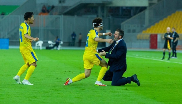 Al Gharafau2019s Ahmed Alaaeldin (second right) celebrates with coach Andrea Stramaccioni after scoring in the AFC Champions League Group C match against Ahal FC in Jeddah on Sunday.