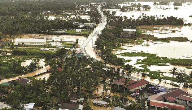 A highway and houses lie submerged by flood waters in Abuyog town, Leyte province, southern Philippines, yesterday following heavy rains brought about by Tropical storm Agaton.