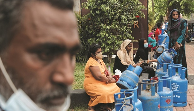 People wait in a line to buy domestic gas on a main road amid the countryu2019s economic crisis in Colombo on Tuesday. Acute food and fuel shortages, as well as long daily electricity blackouts, have brought widespread suffering to the countryu2019s 22mn people in its most painful downturn since independence in 1948.