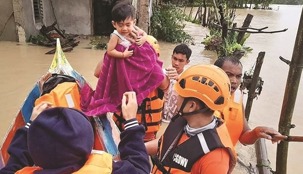 Philippines coast guard personnel evacuate local residents from their flooded homes in the town of Panay, Capiz province after heavy rains brought on by Tropical Storm Megi inundated the area.