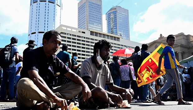 Protestors gathered at the entrance of Sri Lanka's President Gotabaya Rajapaksa office eat while sitting along a road, in Colombo.
