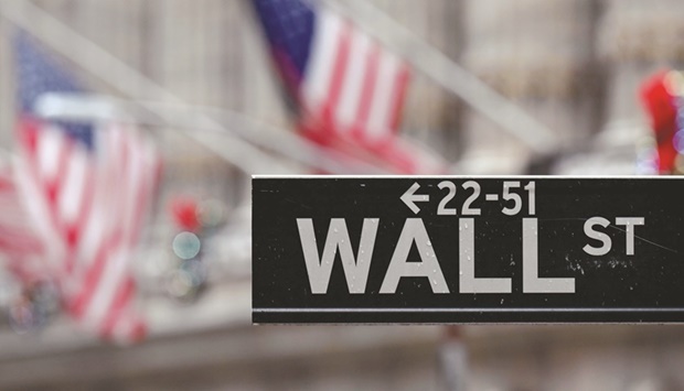 A Wall Street sign is seen outside the New York Stock exchange in New York City. While the S&P 500 has fallen nearly 8% in 2022, utilities have gained over 6%, staples has climbed 2.5%, healthcare has dipped 1.7% and real estate has declined 6%.
