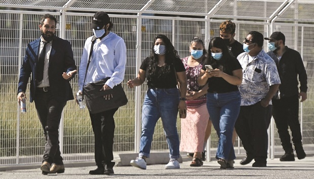 People wear face masks as they wait in line to attend a job fair at SoFi Stadium in Inglewood, California. The government is due to publish its snapshot of first-quarter GDP on Thursday.