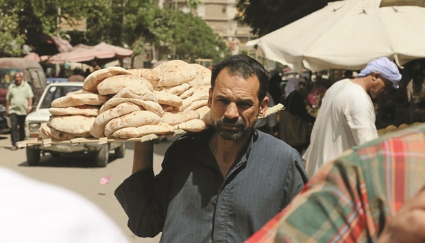 An Egyptian man is holding bread in a market in Cairo (file). Egypt is struggling to maintain a bread subsidy programme used by about 70mn of its citizens.