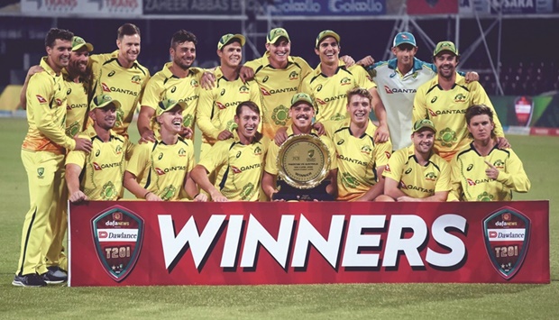 Australiau2019s players pose with the trophy after winning the Twenty20 international match against Pakistan at the Gaddafi Cricket Stadium in Lahore yesterday. (AFP)
