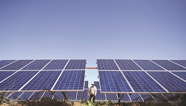 An engineer walks next to solar panels at the National Thermal Power Corporation (NTPC) site at Bhadla Solar Park in Bhadla, in the northern Indian state of Rajasthan. As India chases the target of turning net carbon zero by 2070, the country is seeking to reduce its dependence on fossil fuels with a massive expansion of renewables generation capacity as well as new technologies such as green hydrogen and energy storage - all areas that Adani is focusing on.