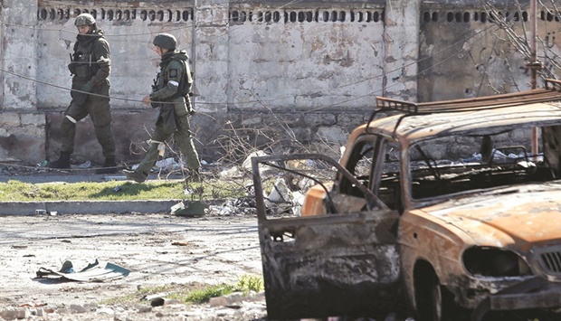 IN THE EYE OF THE STORM: Service members of pro-Russian troops inspect streets during Ukraine-Russia conflict in the southern port city of Mariupol last week. (Reuters)