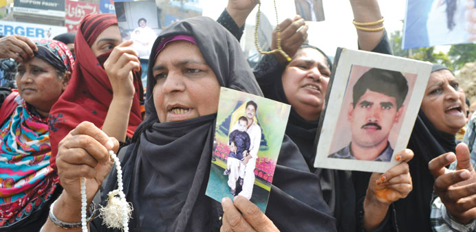 Families of stranded Pakistanis in Yemen hold their pictures in a rally for their rescue in Multan yesterday.