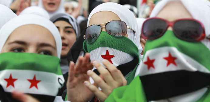 Syrians living in Jordan taking part in a protest against President Bashar al-Assad, marking two years since the start of the uprising, in front of th