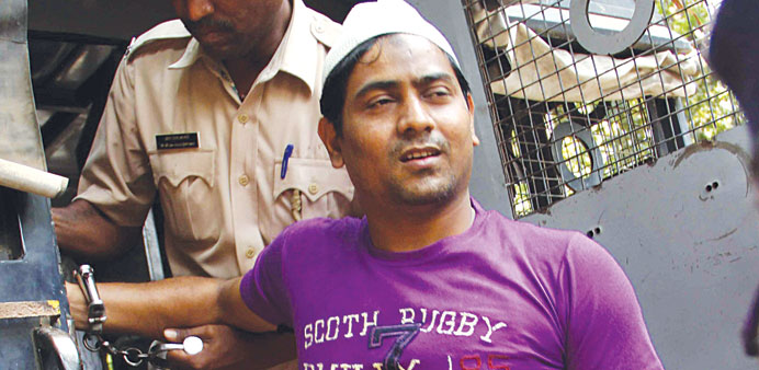 Police officials escort one of the four convicts from a vehicle in Mumbai yesterday.