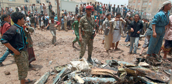 Security forces inspect the scene of the military jet crash in Sanaa in this May 13, 2013, file photo.