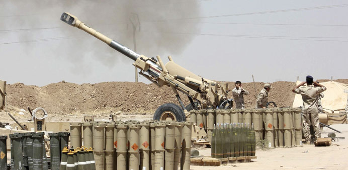Iraqi security forces fire artillery during clashes with Islamic State of Iraq and the Levant on the