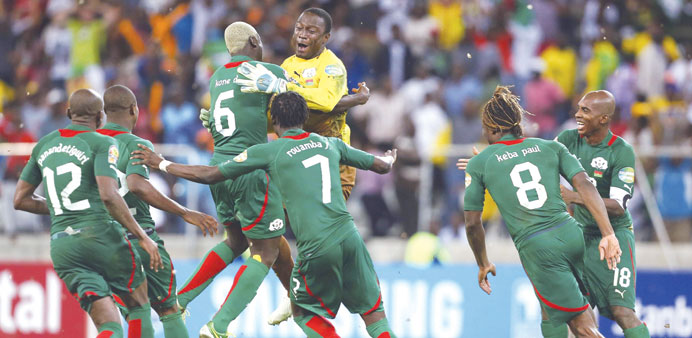   Goalkeeper Daouda Diakite of Burkina Faso (C) leaps into the arms of teammates as they celebrate winning the penalty shootout against Ghana at the M