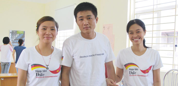   Geriatric nurse Nguyen Huu Lai (centre), 23, posing for a photo with two classmates at a German language class in Hanoi.