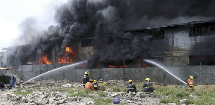 Firefighters attempt to control a raging fire at a factory in Valenzuela City, north of Manila yesterday.