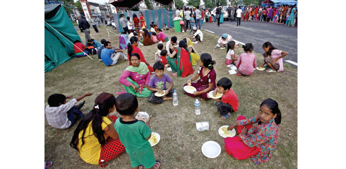 Earthquake affected people eat food at Nepal army pavilion at Tundikhel in Kathmandu yesterday. 