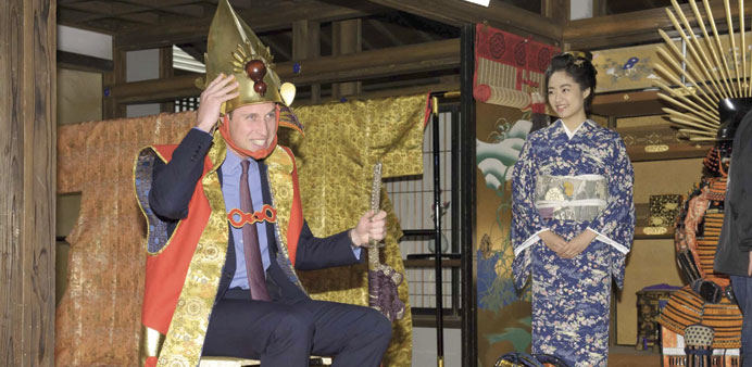 Britainu2019s Prince William, Duke of Cambridge, tries on a samurai costume as Japanese actress Mao Inoue in kimono looks on, during his visit to a Taiga 