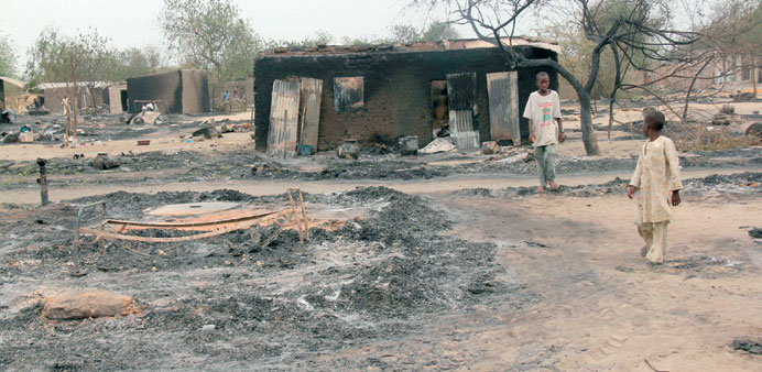 Children walking outside a charred house in the remote northeast town of Baga in Nigeria.