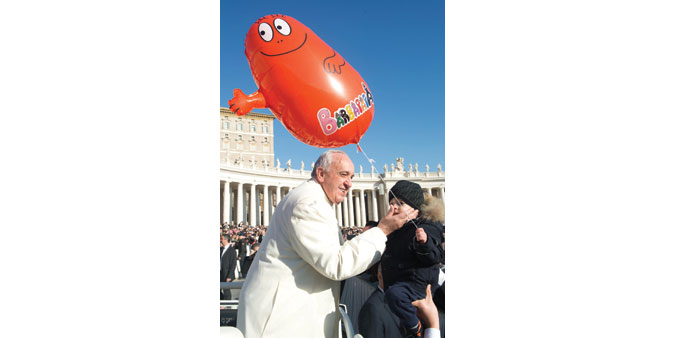 This handout picture released by the Vatican press office shows Pope Francis blessing a child during the weekly audience at Saint Peteru2019s Square in Va