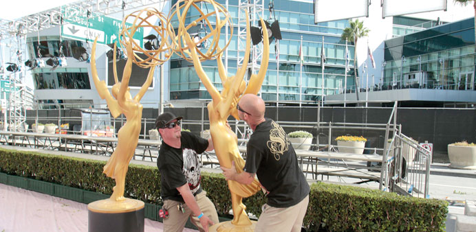 PRIMING FOR EMMY NIGHT: Stagehands Daren Graves, left, and Jeff Hryskanic move Emmy statues outside Nokie Theatre at L A Live . The 66th Primetime Emm