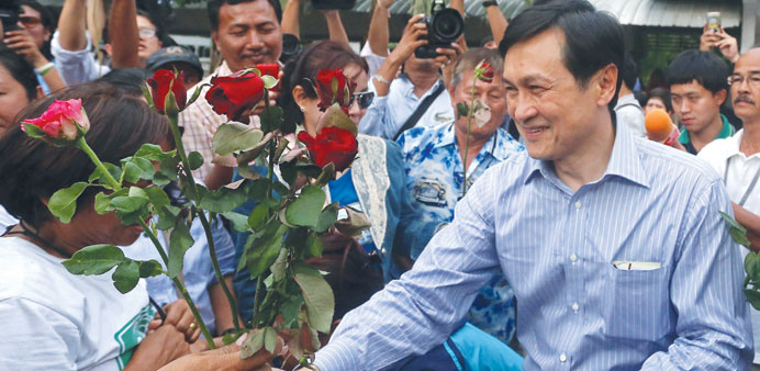 Chaturon Chaisang (right), who was education minister in the government ousted by the military, receives roses from his supporters after his release f